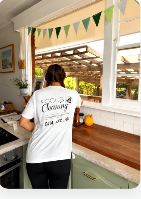 A uniformed Focus cleaner working in a client's kitchen